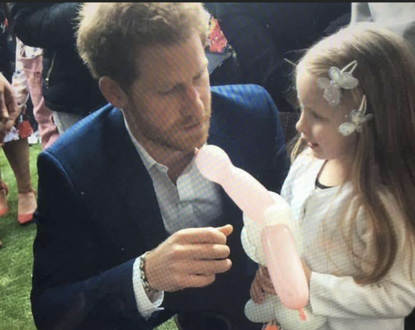 Evie and Prince Harry bonding over a balloon toy
