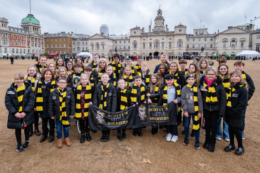 A large group of Scotty's Little Soldiers members in black and yellow Scotty scarves at the London Remembrance Parade