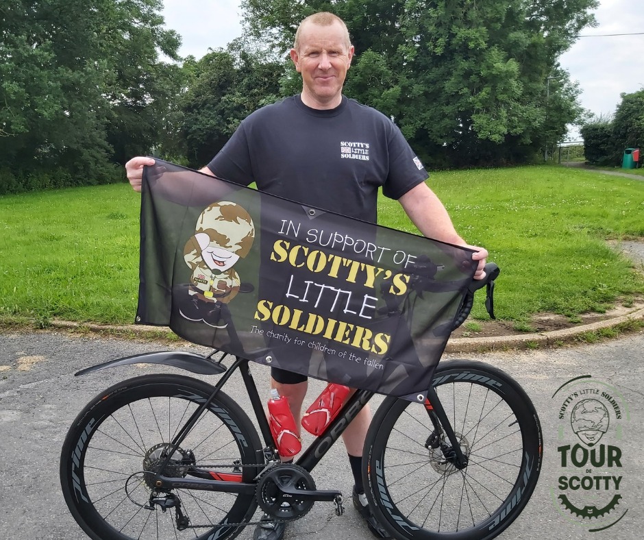 A Scotty supporter stood beside his bike, waving the Scotty flag
