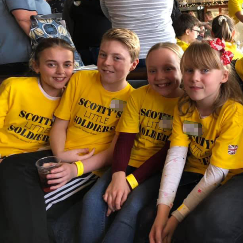 Bereaved British Forces young people at Scotty's Little Soldiers London Christmas Party wearing yellow t-shirts
