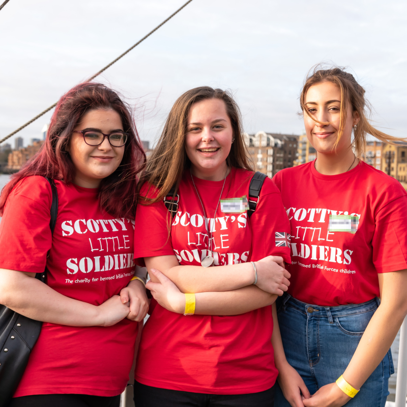 Teenage Scotty members in red t-shirts at Christmas Party on the Thames in London. Bereaved Military Young People